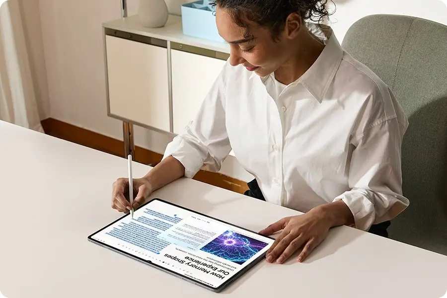 Žena u stolu píše perem S Pen na Galaxy Tab S12 Ultra položeném na šířku