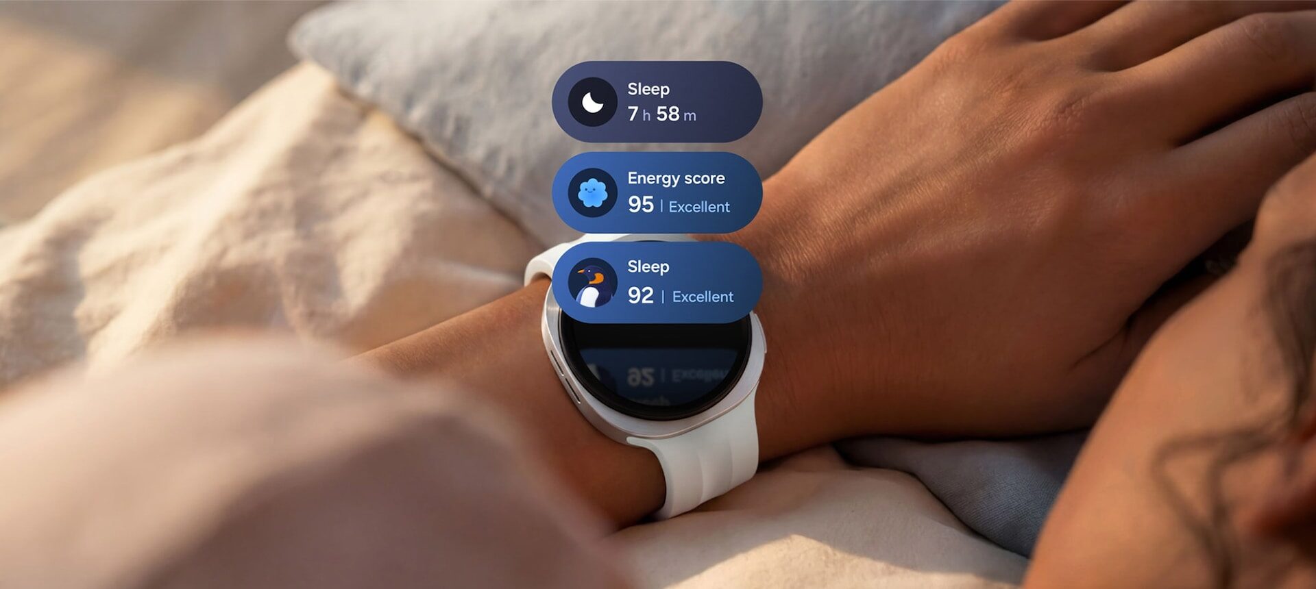 Galaxy Watch9 na zápěstí spícího člověka s dlaždicemi délky spánku a Energy skóre