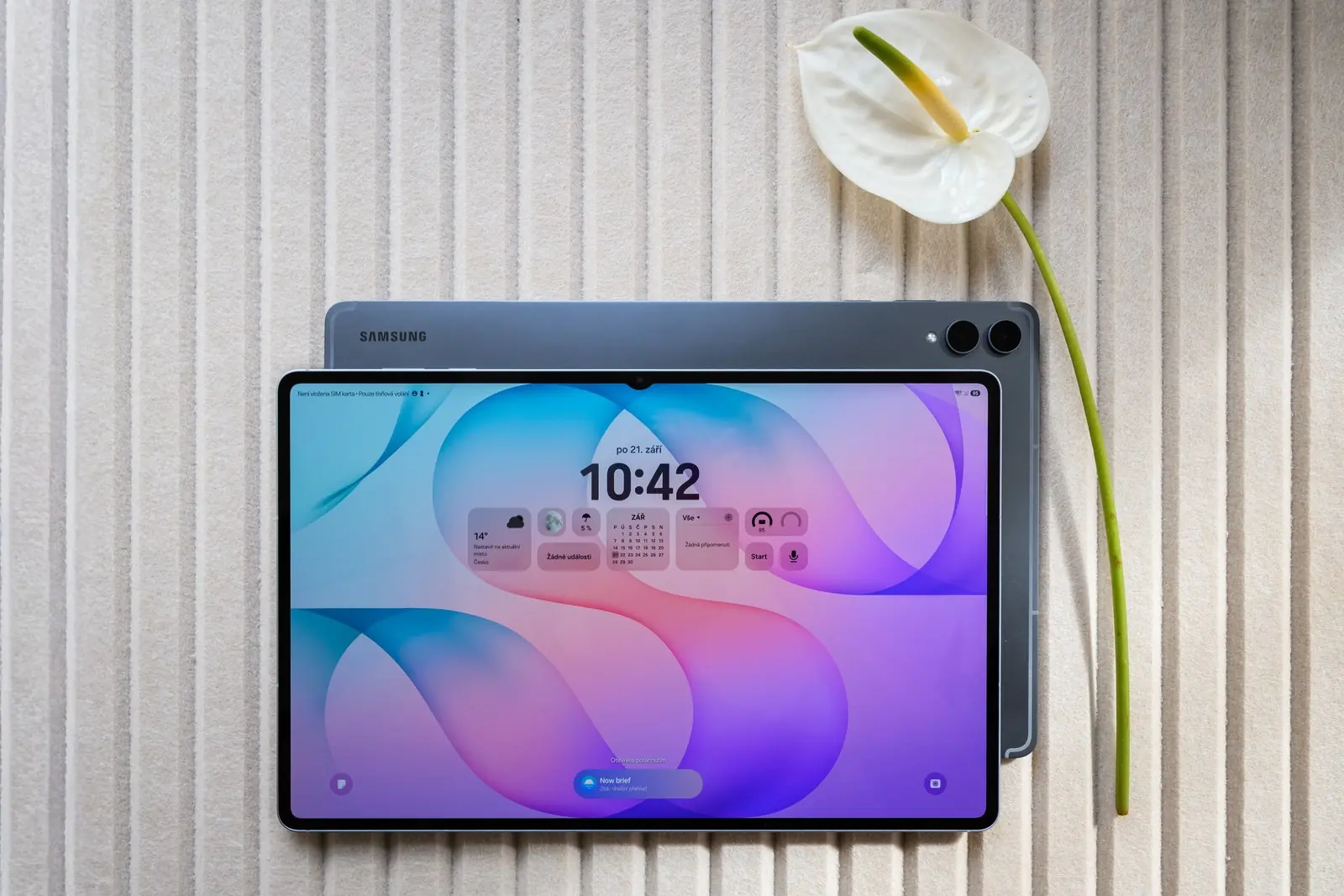 Dva tablety Galaxy Tab S12 Ultra na stole, přední se zamykací obrazovkou a hodinami